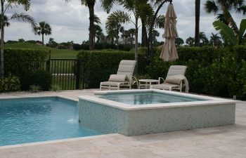 backyard swimming pool with light blue water color and paver deck