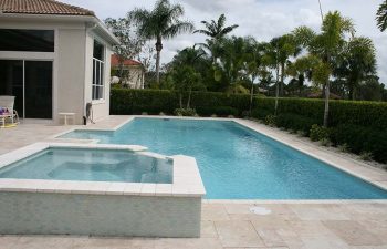 backyard swimming pool with light blue water color and paver deck