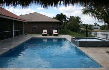 classic backyard swimming pool with jacuzzi and a waterfall