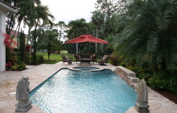 landscaped garden with a swimming pool and outdoor furniture on a deck