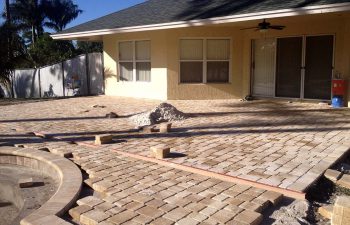 backyard swimming pool under construction - installing paver deck