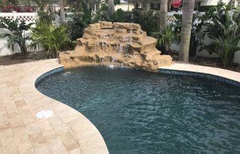 backyard swimming pool with waterfall and dark water color