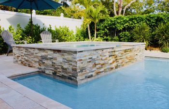 backyard pool and jacuzzi with Travertine walls