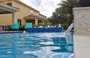 backyard swimming pool with and jacuzzi and built-in waterfall and fountains