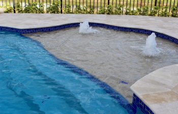 backyard swimming pool basin with two built-in fountains