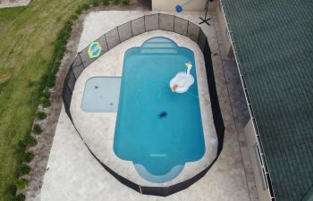 aerial view of a fenced backyard swimming pool