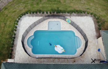 aerial view of a fenced backyard swimming pool