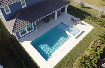 aerial view of a swimming pool with jacuzzi in a landscaped backyard