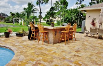 a pool bar with stools on a backyard swimming pool patio