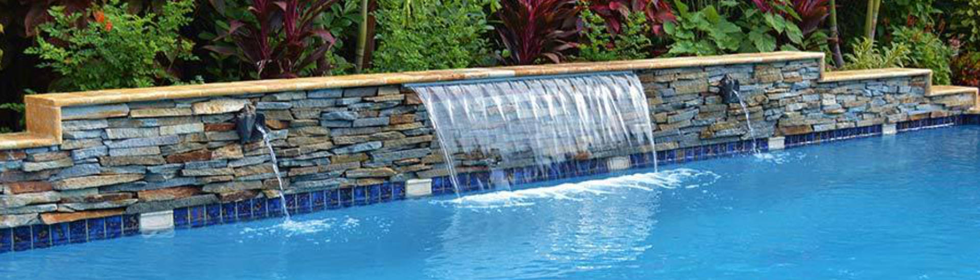 backyard swimming pool with a waterfall