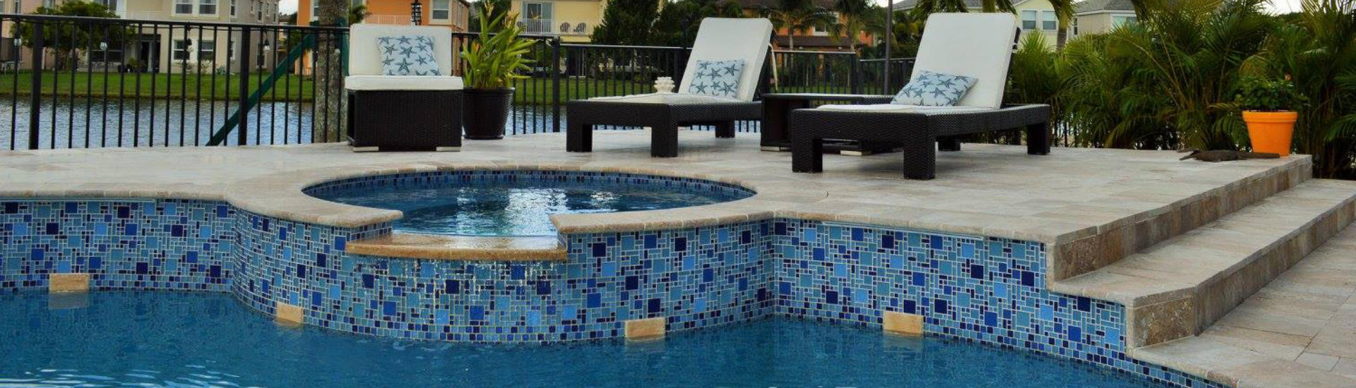 backyard swimming pool with decotartive tiles and sun loungers on a deck